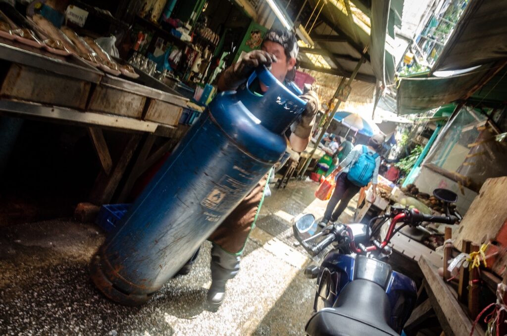 Man Rolling Butane Tank, Chinatown, Bangkok, Thailand