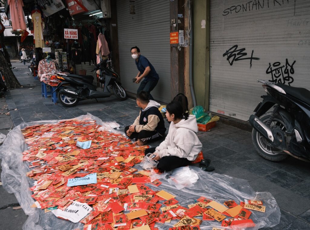 Children selling red packets at The Old Quarter, Hanoi.